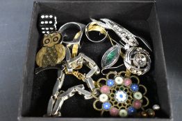 A mixed lot of costume jewellery and trinkets, including brooches, rings, bracelet and more.