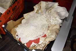 A selection of lace work, embroidered and similar table mats and place settings.
