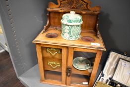 An early 20th century tobacco pipe smokers compendium cabinet, having an Oak case with glazed