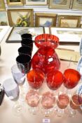 A selection of colour glass wares including four black wine glasses, three large red wine glasses,
