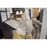 An Art Deco Butterfly form room heater converted into a lamp, in aluminium on a swivel arm branch on