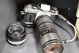 A vintage Canon AE-1 camera body with a 50mm lens and a Vivitar 58mm lens.