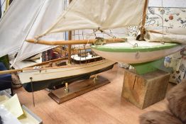 A vintage 1950's wooden sail boat with a similar more modern model of a Yacht