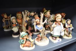 Thirteen Goebel Hummel figurine studies including Girl Reading Book and Girl with geese