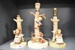 Three Goebel Hummel figural lamp bases including two of Girl with Goat and One of Boy up a Tree.
