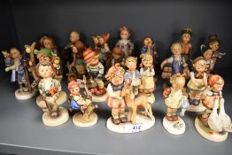 Twenty Two Goebel Hummel figures in varying poses and subjects, all in good condition.