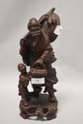 A carved Chinese depiction of traditionally dress gent and child with basket.