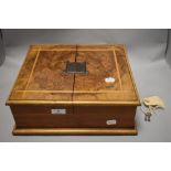 An early 20th century figured walnut box (former canteen) having inlaid satin wood detailing to lid,