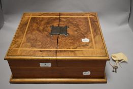 An early 20th century figured walnut box (former canteen) having inlaid satin wood detailing to lid,