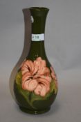 A 1982 dated Moorcroft pottery vase of elongated baluster form, having green ground with tube