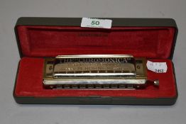 A boxed 'The Chromonica' Hohner harmonica.