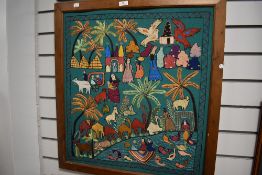A large ethnic style needle work, having animals, people, trees and houses depicted throughout on