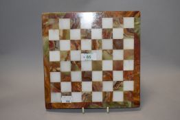 An onyx chess board, interspersed with white onyx squares, having polished finish.
