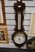 An early 20th century aneroid banjo barometer, with carved details and bevelled glass face in