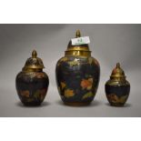 Three 20th century brass lidded urns with enamelled decoration.