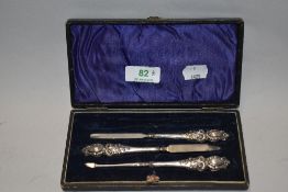 An Edwardian silver mounted manicure set in blue fabric lined box, one item missing.