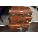 Four early 20th century graduated leather suitcases