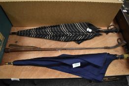 Two vintage umbrellas and a leather bound riding crop