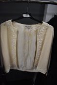A 1950s/60s cream wool cardigan having heavily beaded decoration and lined in silk, having Wong