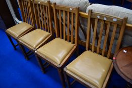 A set of four golden oak railback dining chairs