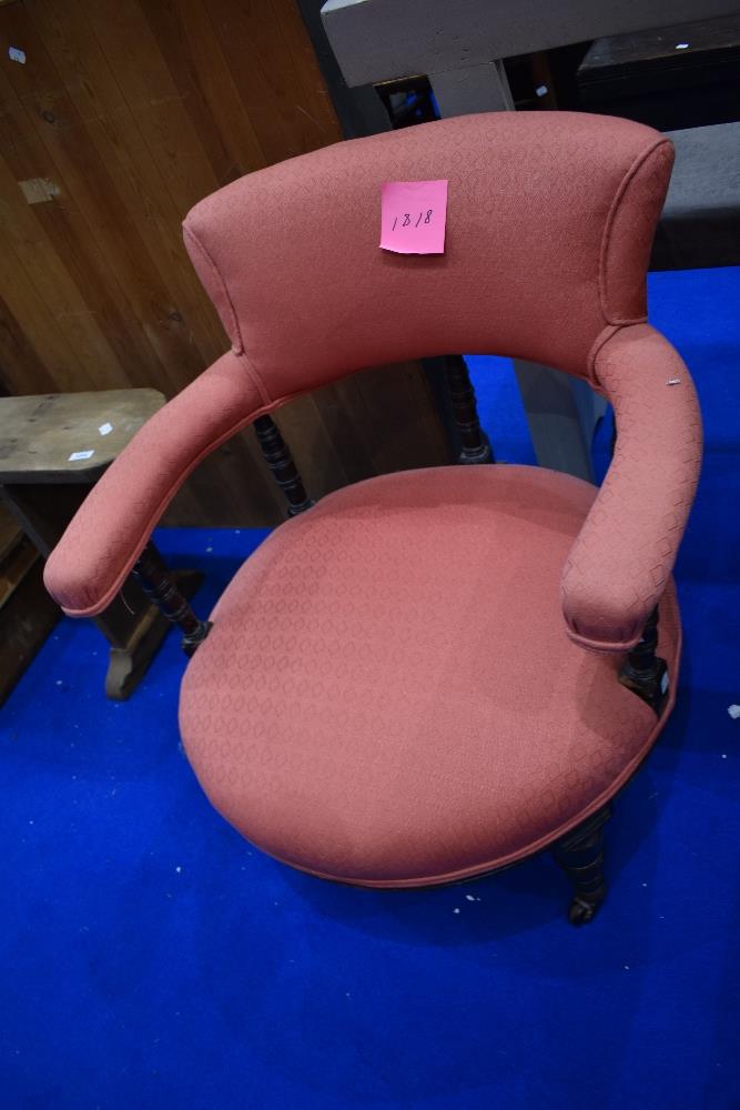 A Victorian mahogany low seat armchair with turned frame and later upholstery