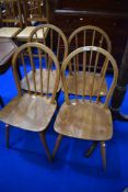 A set of four Ercol dining chairs with Elm seats and hoop backs.