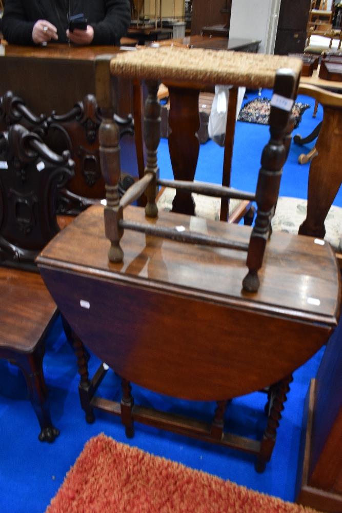 A mid to late 20th Century oak gateleg small dining table and a strung stool on turned frame