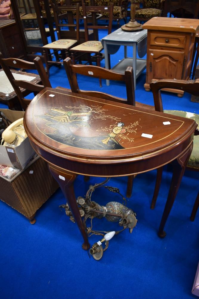 A vintage half moon table having oriental decoration