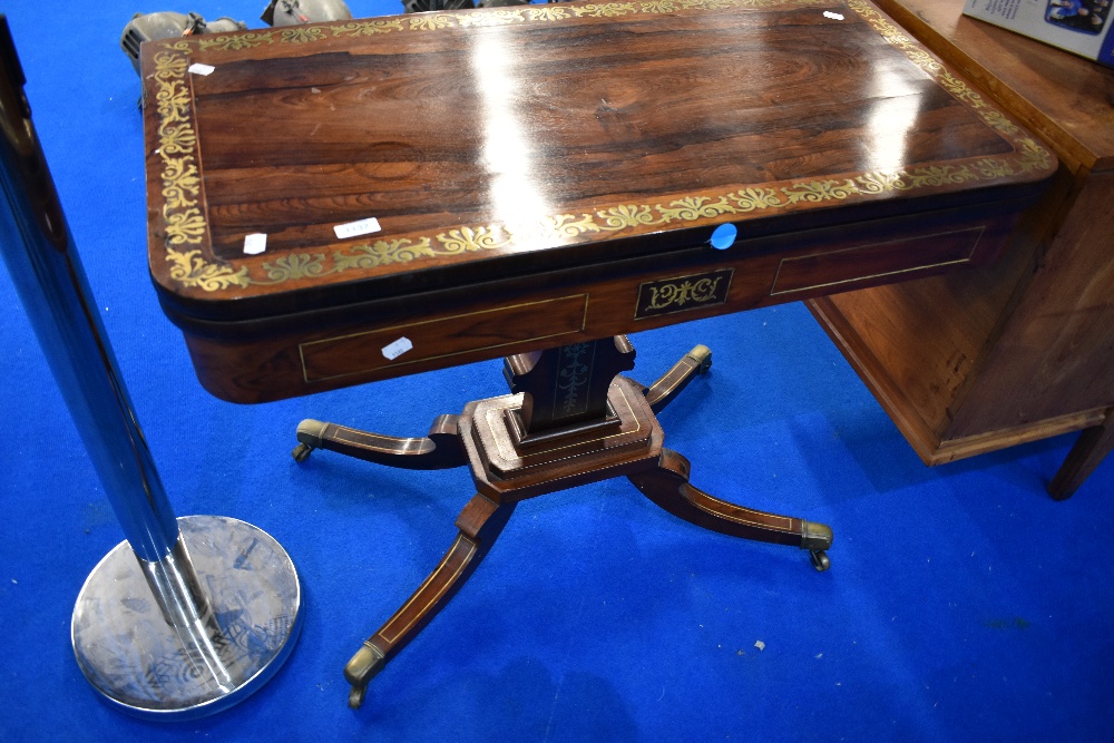 A 19th Century Continental style rosewood fold over card table having extensive brass inlay