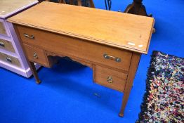 An early 20th Century golden oak dressing table or desk, having later brass handles. Width approx.