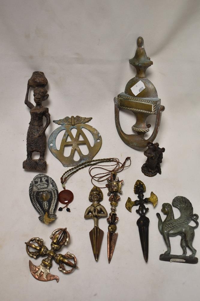 A selection of metal wares including door knocker, an early AA badge and ethnic figures.