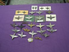 A collection of Parachute Regimental Cap Badges and Collar Badges along with Shoulder Titles