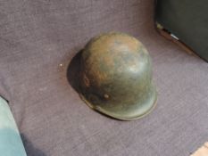 A WW2 German Steel Helmet, Swastika on red shield and eagle holding Swastika decals present, part of
