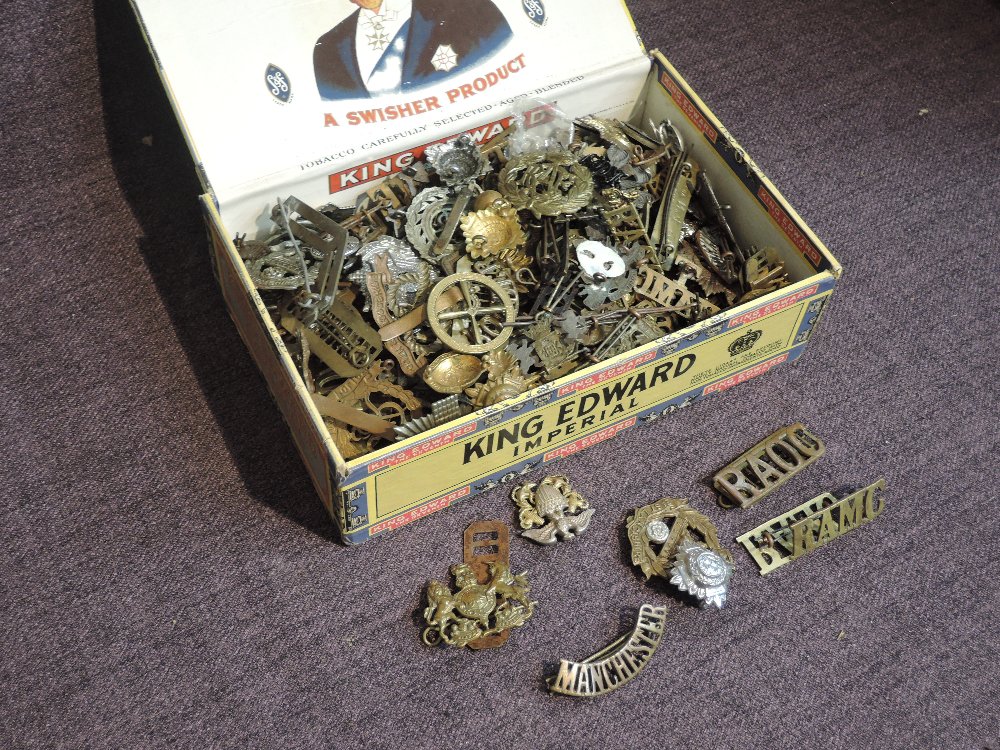 A cigar box of mainly Military Cap Badges including Kings Own, Royal Lancaster, Royal Flying Corp,