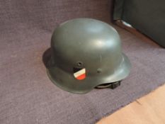 A German WW2 period Steel Helmet with eagle and Swastika Decal and black, white and red shield