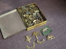 A tin box of Military Cap Badges, Shoulder and Colar Titles including S.S Commando, 3rd Kings Own