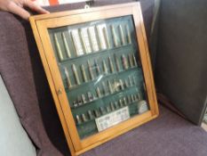 A wooden and glass display case containing inert Bullets, various all deactivated 48 bullets