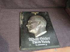 A wooden plaque having Silvered Head of Adolf Hitler, marked to neck HB in circle, underneath