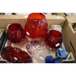 A collection of coloured glass including three vintage red goblet vases and a similar art glass