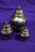 Three 20th century brass lidded urns with enamelled decoration.