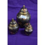 Three 20th century brass lidded urns with enamelled decoration.