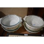 Four Pyrex oven to tableware casserole dishes with lids.