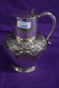 An early 20th Century silver plated water jug with an embossed floral pattern.