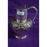 An early 20th Century silver plated water jug with an embossed floral pattern.