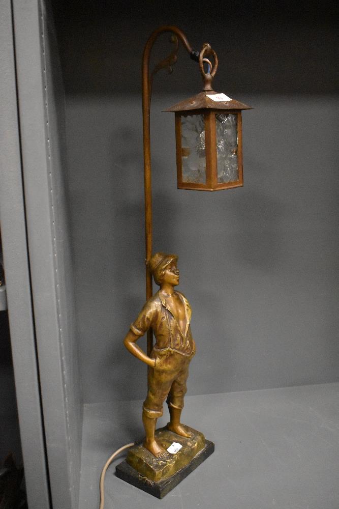 An early 20th century French figural lamp base of a boy under a street lantern.