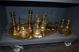 A selection of brass wares including a pair of fire dogs, candle sticks and a large brass tray.