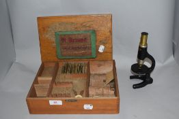 A 20th century Milbro x 250 scientific childrens microscope with case and some slides.