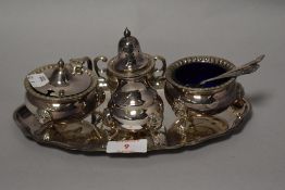 A fine silver plated condiment set including blue glass salts dish, mustard pot and pepper pot.