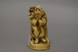 An antique porcelain match holder in the form of a bearded winter man, having a blue anchor mark