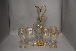 A vintage Bohemian glass jug and glasses set of six with a floral gilt pattern.